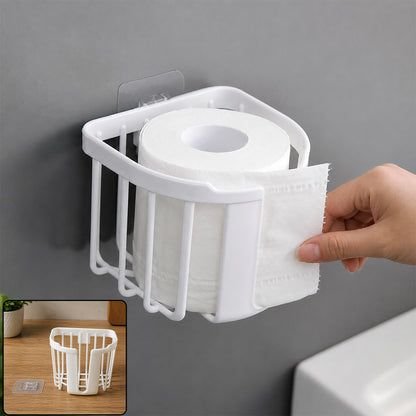 A white plastic toilet paper holder is mounted on a gray wall, holding a roll of toilet paper as a hand tears a sheet.