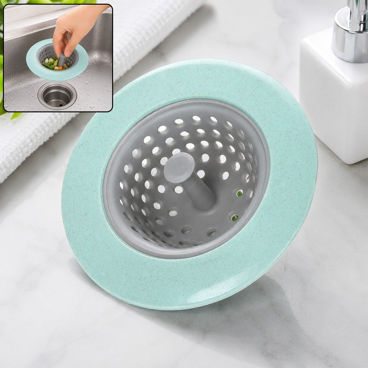 A mint green and grey silicone sink strainer basket on a marble counter with an inset image of it in use.