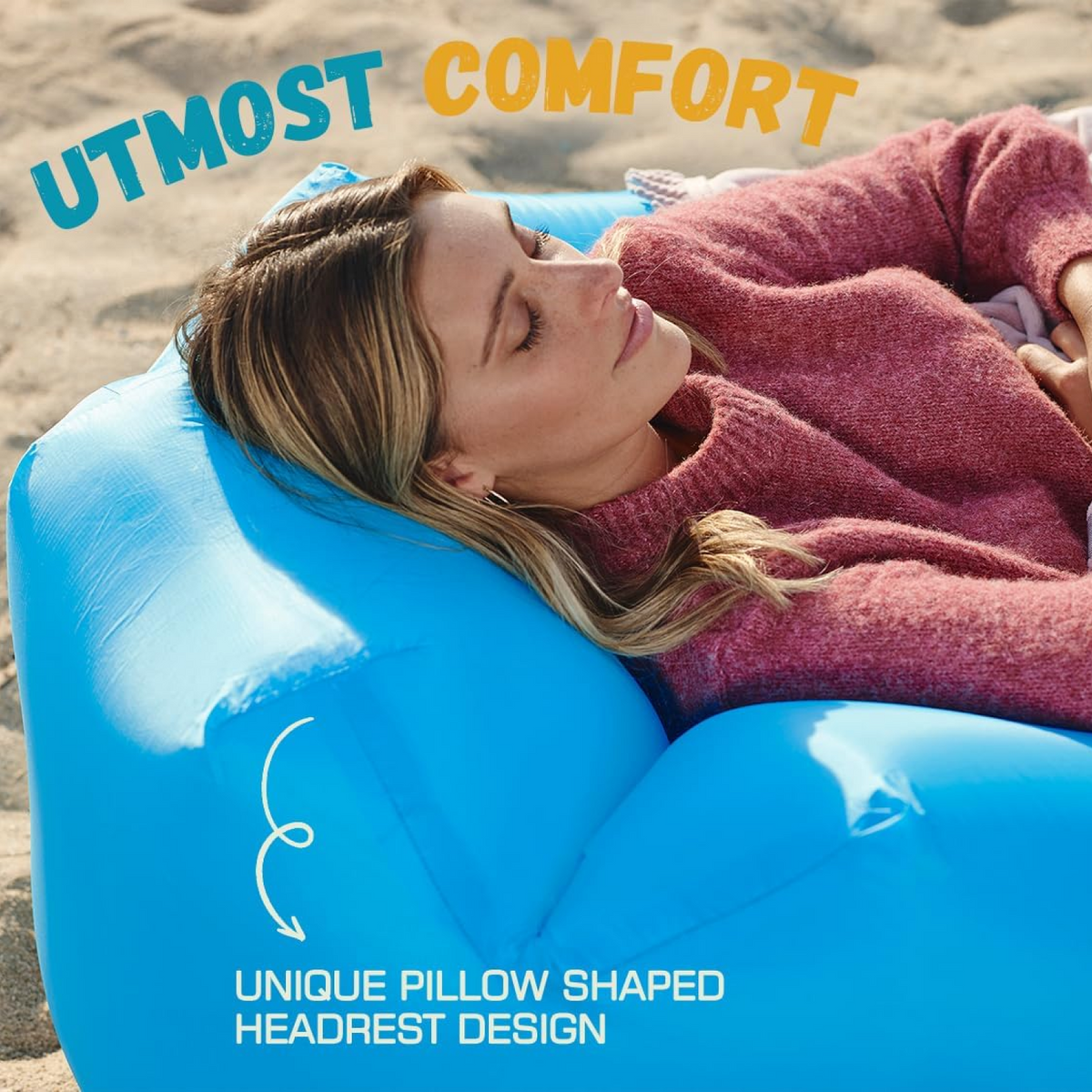 A close-up shows a woman sleeping comfortably on the blue inflatable lounger's unique pillow-shaped headrest on a beach.