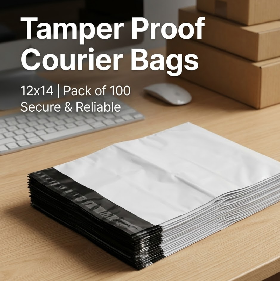 A stack of white poly mailer bags with black seals on a wooden desk, with a computer keyboard and mouse in the background.