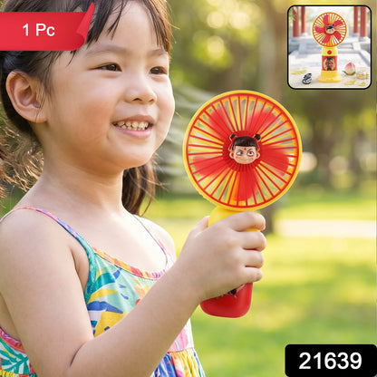 A red and yellow mini fan with a cartoon character face in the center, held by a smiling young girl.