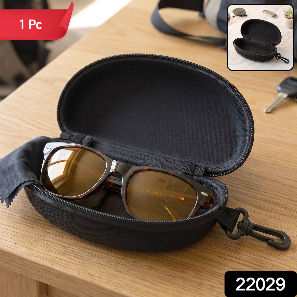 An open black hard shell sunglasses case with brown sunglasses and a black cleaning cloth inside, on a wooden table