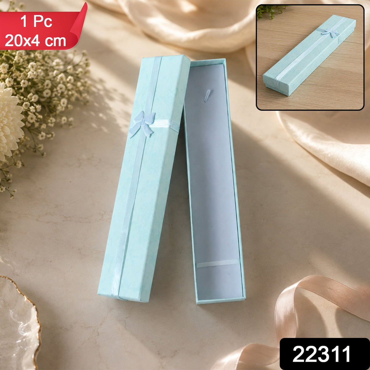 An open light blue rectangular gift box with a light blue ribbon and bow, on a light surface with flowers, with a red label