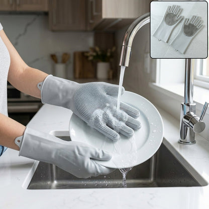 A person wearing grey silicone gloves with scrubbing bristles washes a white plate under running water in a kitchen sink