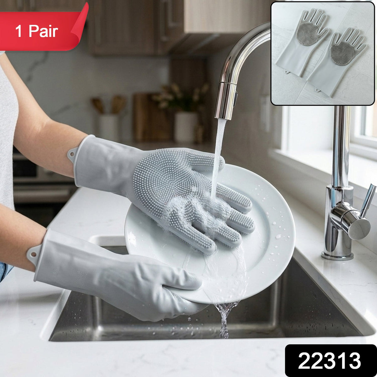 A person wearing grey silicone gloves with scrubbing bristles washes a white plate under running water in a kitchen sink,