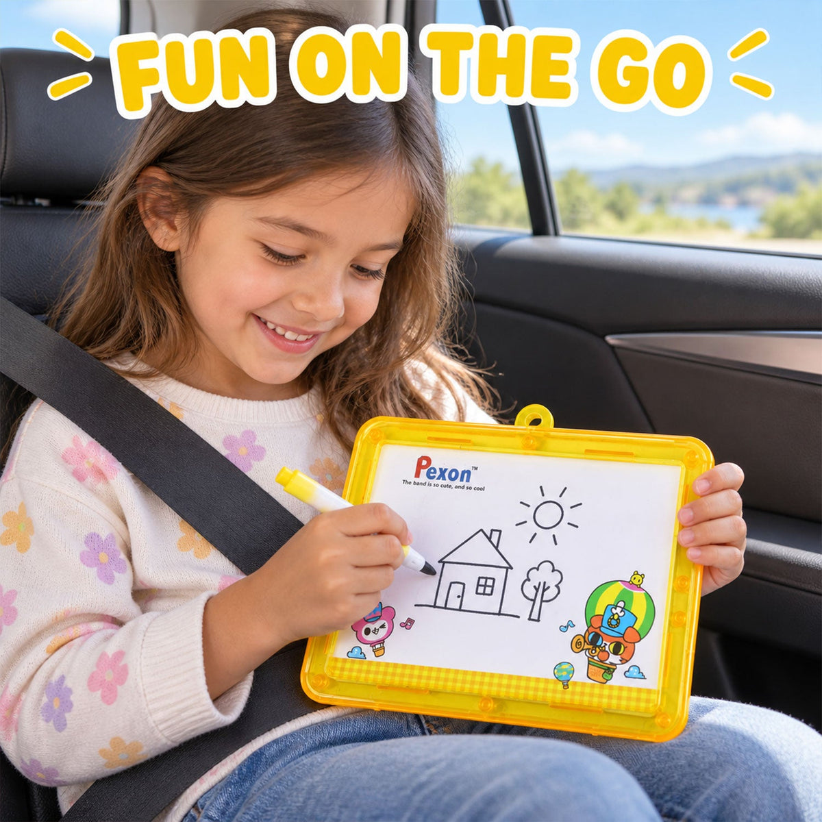 A smiling young girl in a car seat draws a house on a yellow-framed Pexon writing board with a white marker. The background