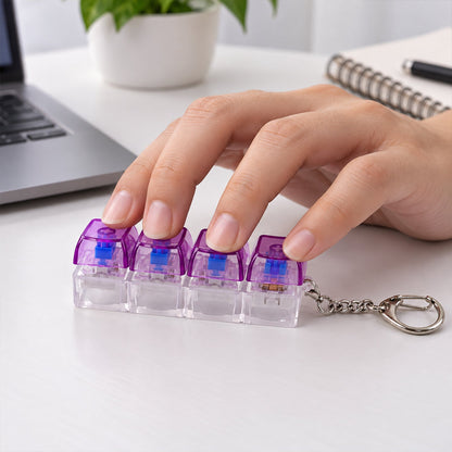 A hand presses down on the four purple and clear keyboard switches of a keychain on a white desk.