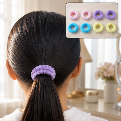 A child with dark hair wears a purple fluffy elastic hair band in a ponytail, with an inset of eight colorful bands.