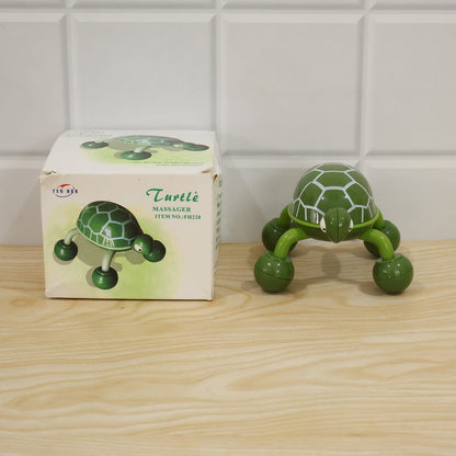 Green plastic turtle shape body massager shown with its retail packaging