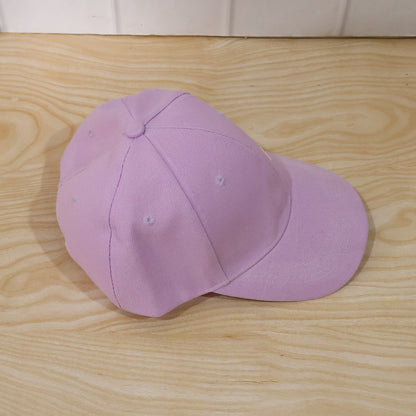 Side view of a plain lavender baseball cap with "Summer Vibes" embroidery on a light wooden surface.
