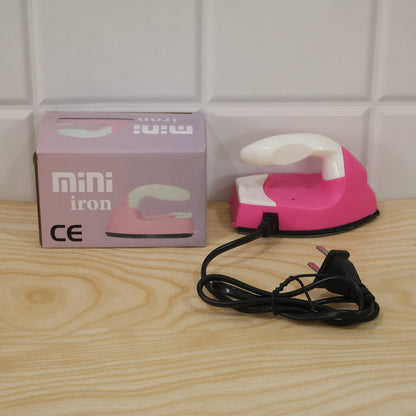 Lifestyle image of pink portable mini electric iron