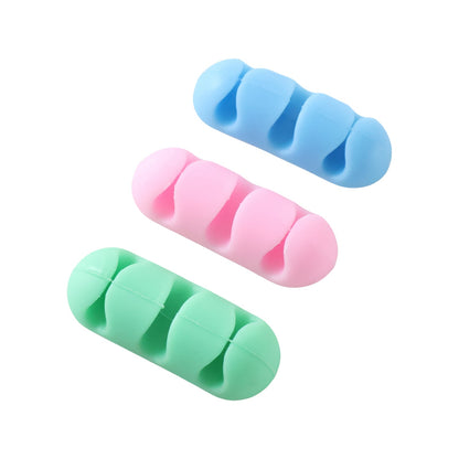 Three silicone cable organizers in blue, pink, and green are displayed on a white background.