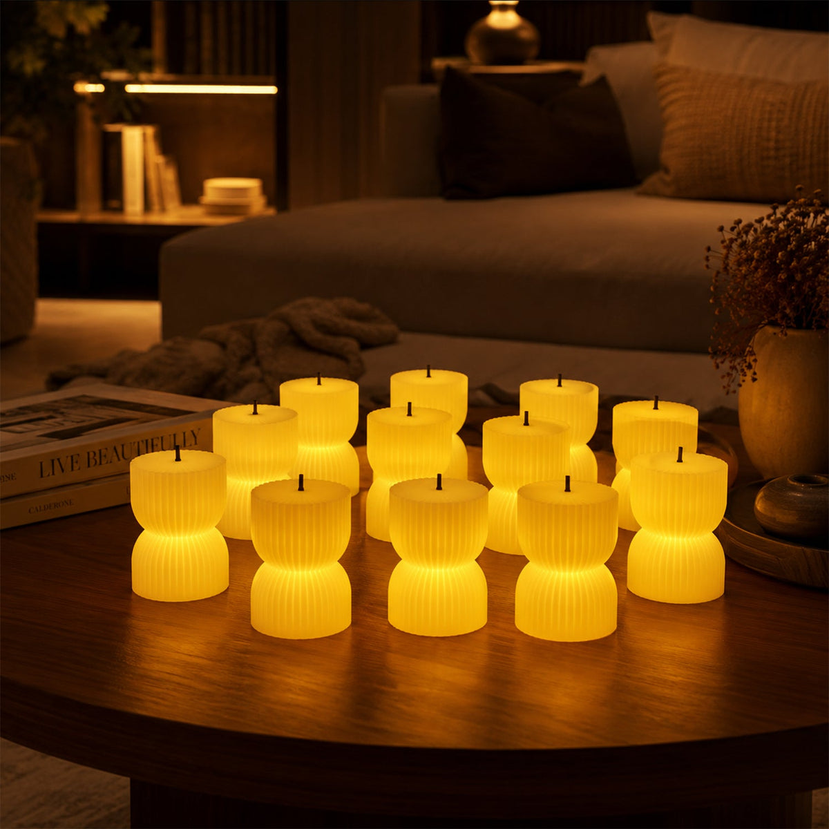 Twelve illuminated, ribbed, hourglass-shaped LED candles glow on a round wooden table in a dimly lit living room.