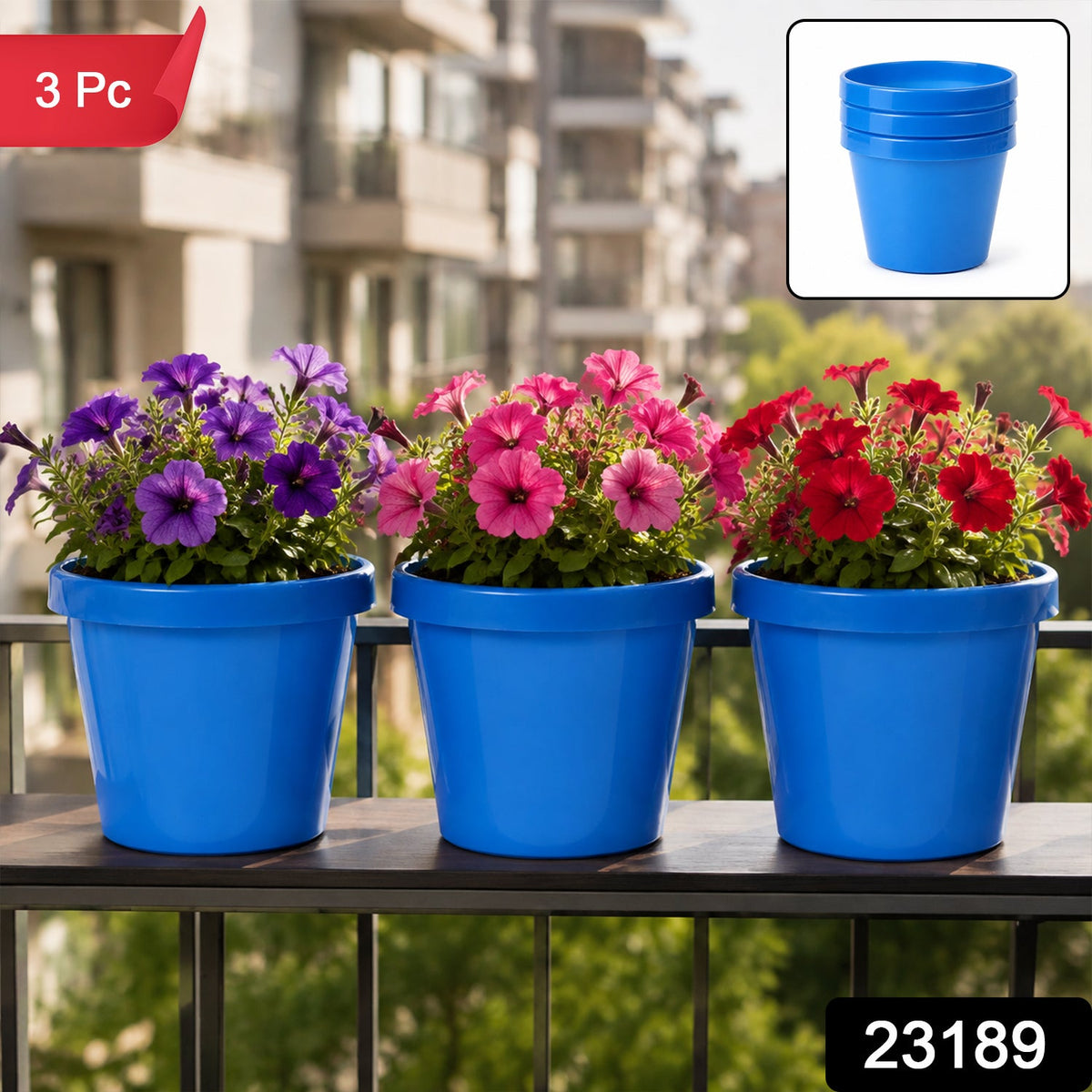 Three blue plastic planters with purple, pink, and red petunias on a balcony railing.