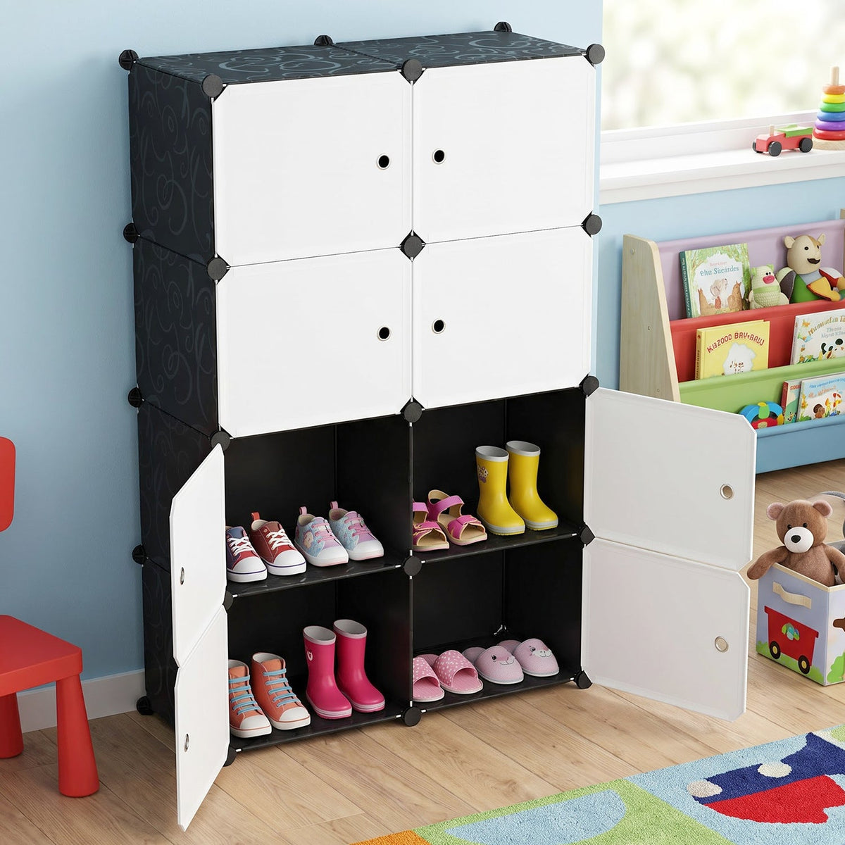 Black and white modular storage cabinet in a child's room with open compartments showing shoes.