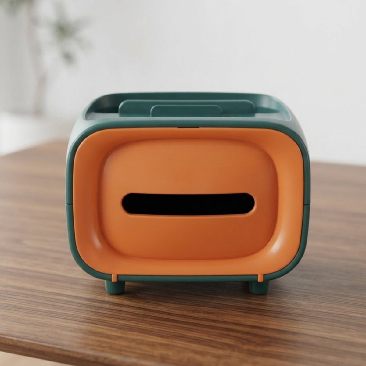 Green and orange rectangular tissue box with a wide opening on a wooden table.