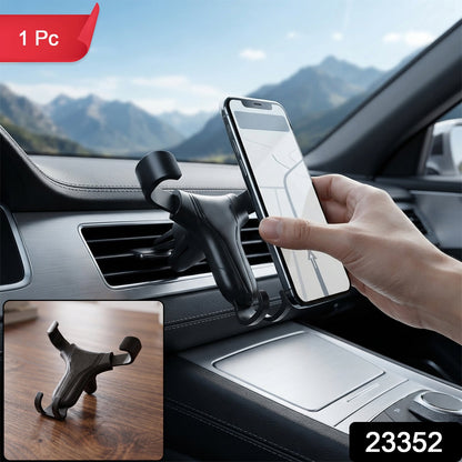 A hand placing a phone into a black gravity lock car phone holder mounted on a car's air vent, with a smaller inset image of