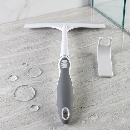 A white and gray glass wiper and a white hook on a marble surface with water droplets.