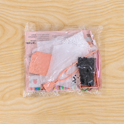 A clear plastic package containing the fuse bead craft kit, showing various components like beads, tools, and instructions