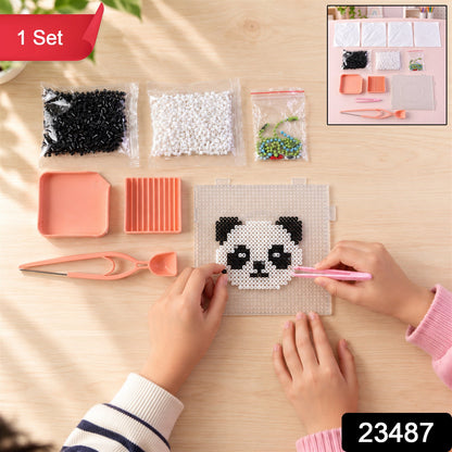 Overhead shot of a child's hands crafting a panda with fuse beads, with an inset showing the complete kit components.