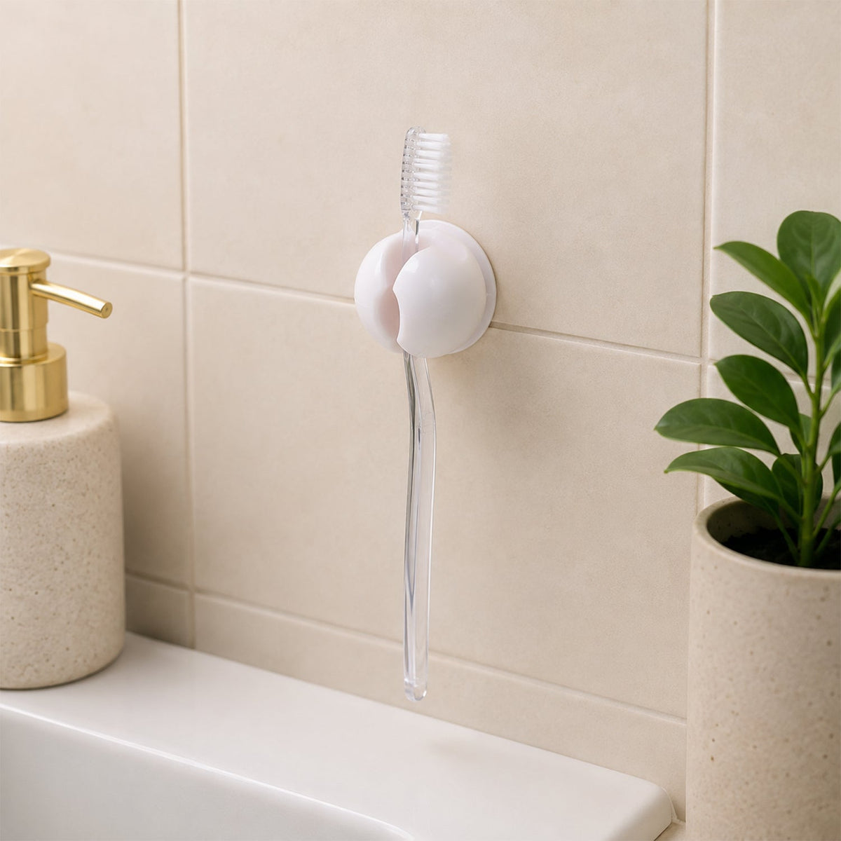 A white toothbrush holder clip on a tiled wall, holding a clear toothbrush above a sink, with a soap dispenser and – view 8