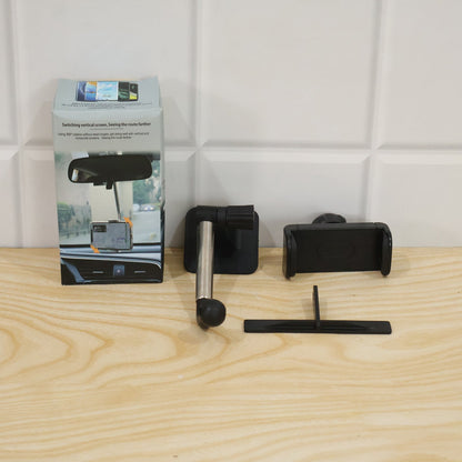 Disassembled car phone holder components next to its product packaging on a light wooden surface.