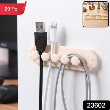 A beige self-adhesive cable organizer clip with five flower-shaped holders, securing black, white, and gray USB – view 2