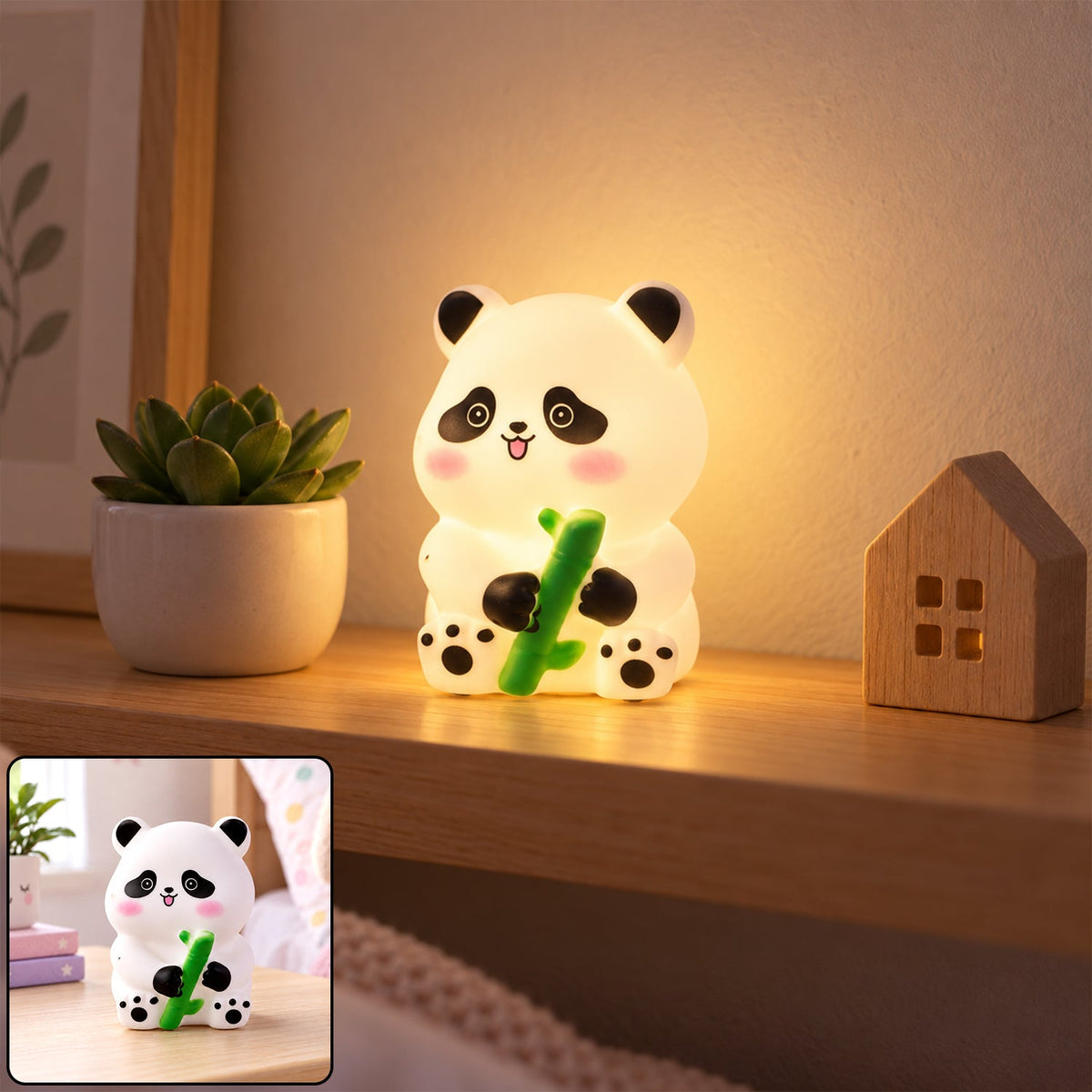 Glowing white panda night light with black ears and paws, holding a green bamboo stalk, on a wooden shelf next to a small