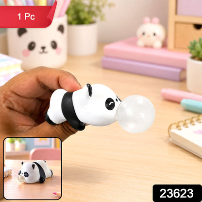 A hand holds a panda squishy toy with a clear bubble, with a small inset showing the toy on a desk.