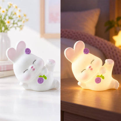 Reclining rabbit night light with warm glow on a bedside table