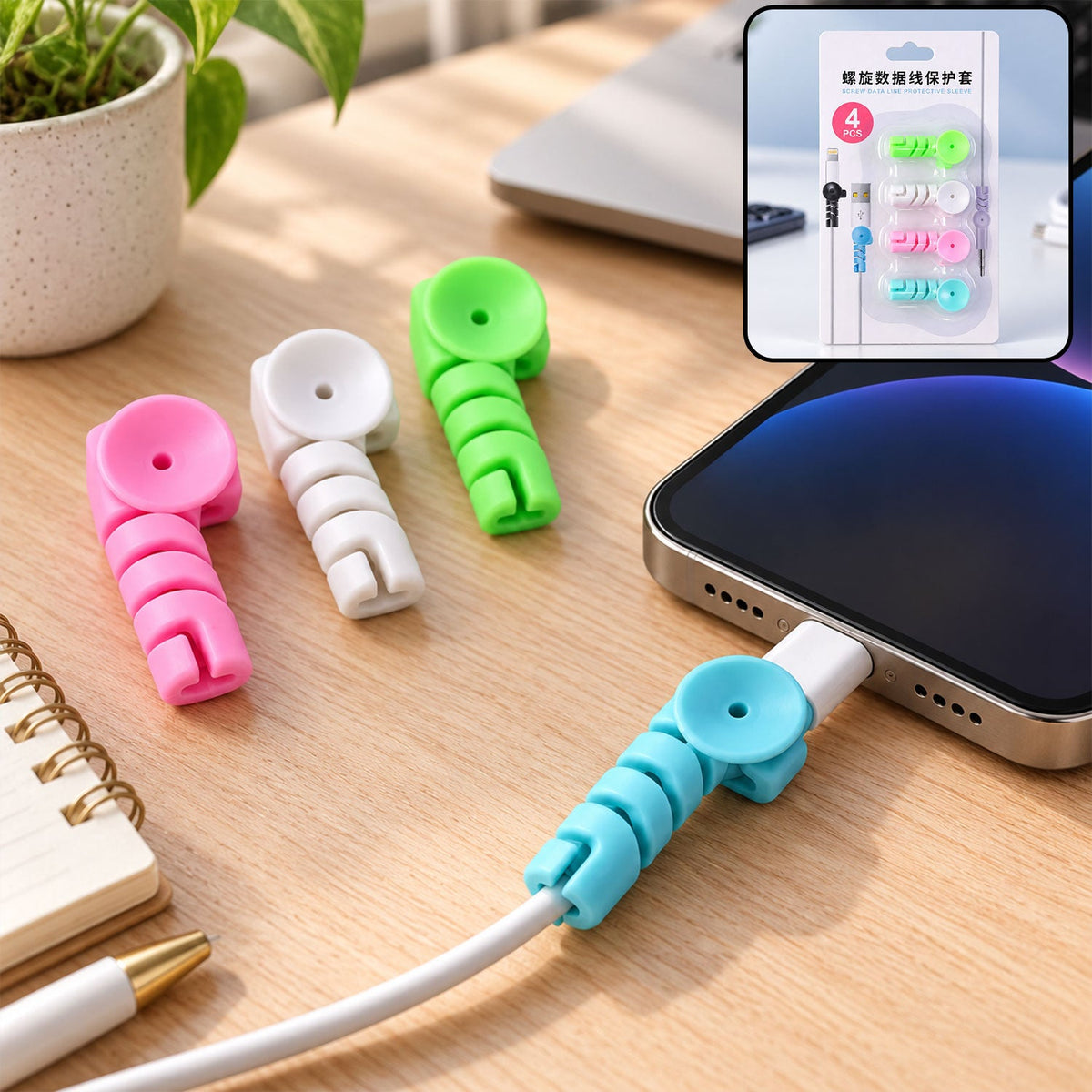 Four colorful spiral silicone cable protectors on a desk, one attached to a phone charging cable.