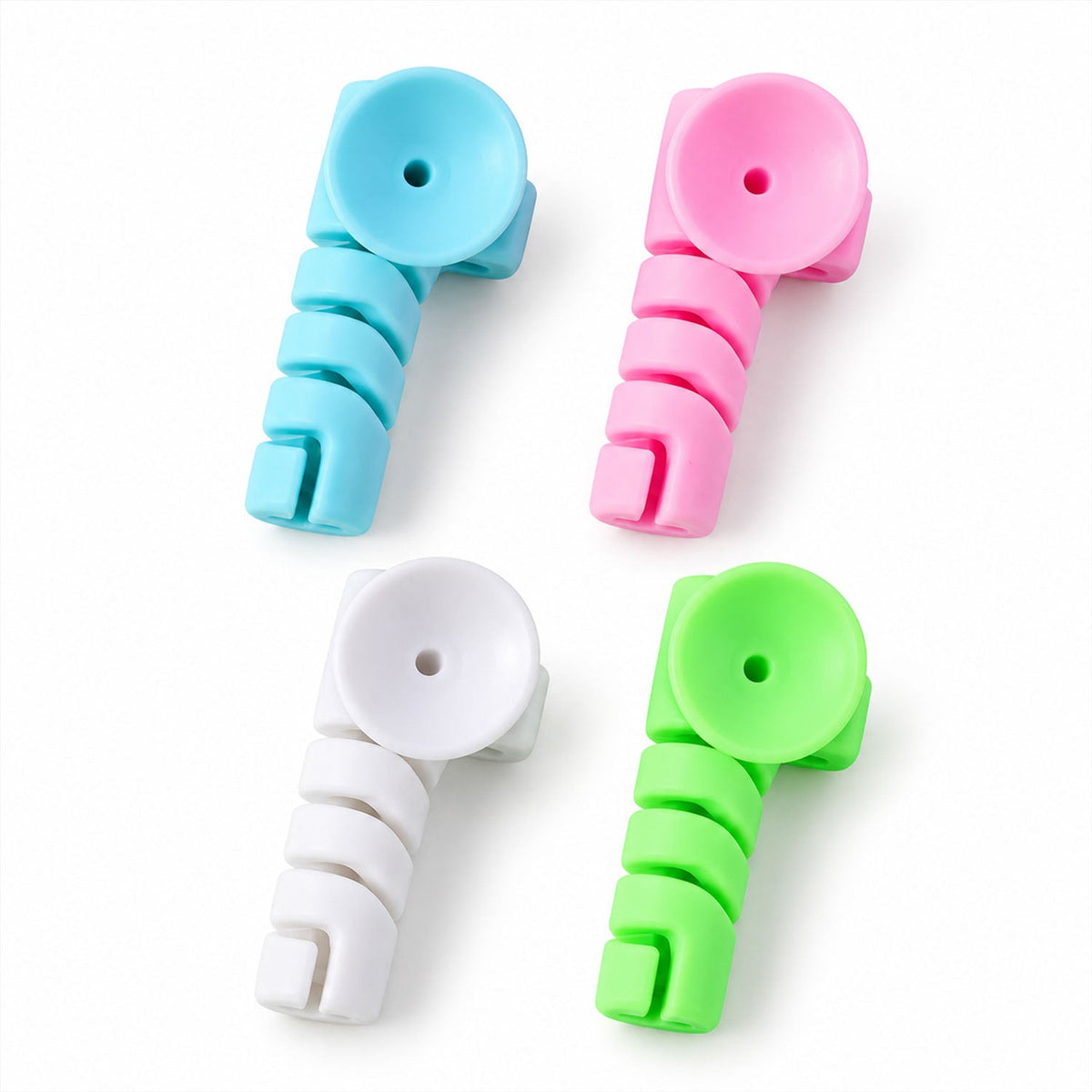 Four colorful spiral silicone cable protectors in blue, pink, white, and green arranged on a white surface.