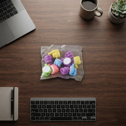 An overhead view of a clear plastic bag containing colourful thumbs-up clips on a wooden desk, surrounded by a laptop,