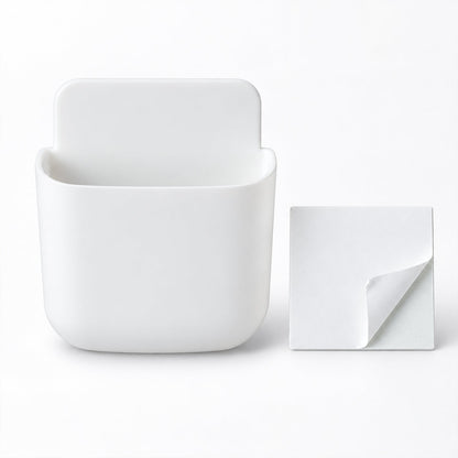 A white, empty, rounded rectangular adhesive organizer sits next to a square white adhesive pad.