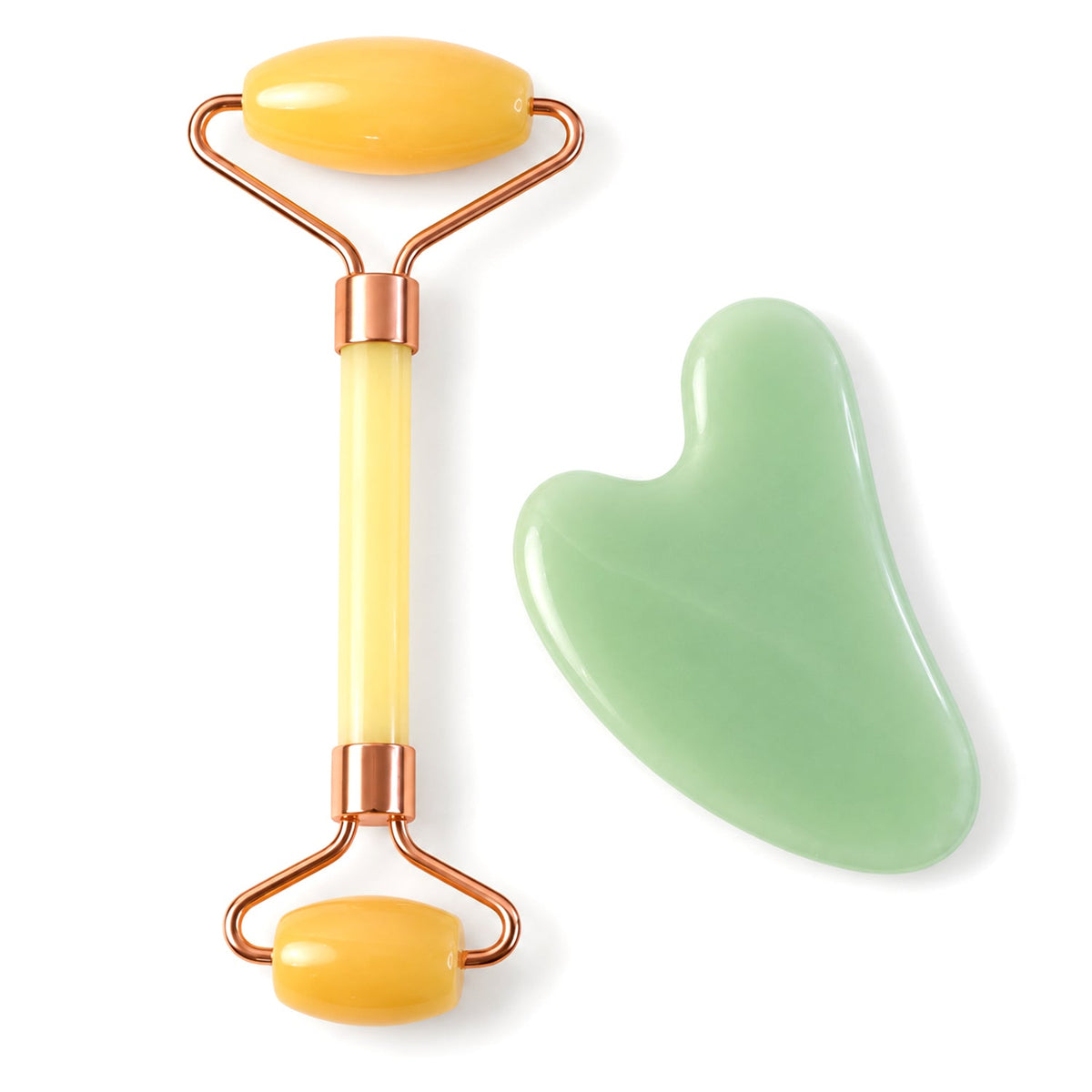 A yellow facial roller with rose gold accents and a green gua sha tool are displayed together.