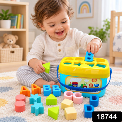 A baby happily plays with a blue and yellow shape sorter bucket, holding a green triangle block and surrounded by other