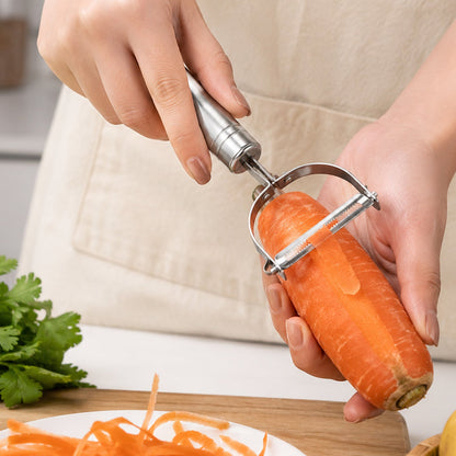 A person's hands using a silver stainless steel peeler to peel an orange carrot, with peeled shavings on a white plate.