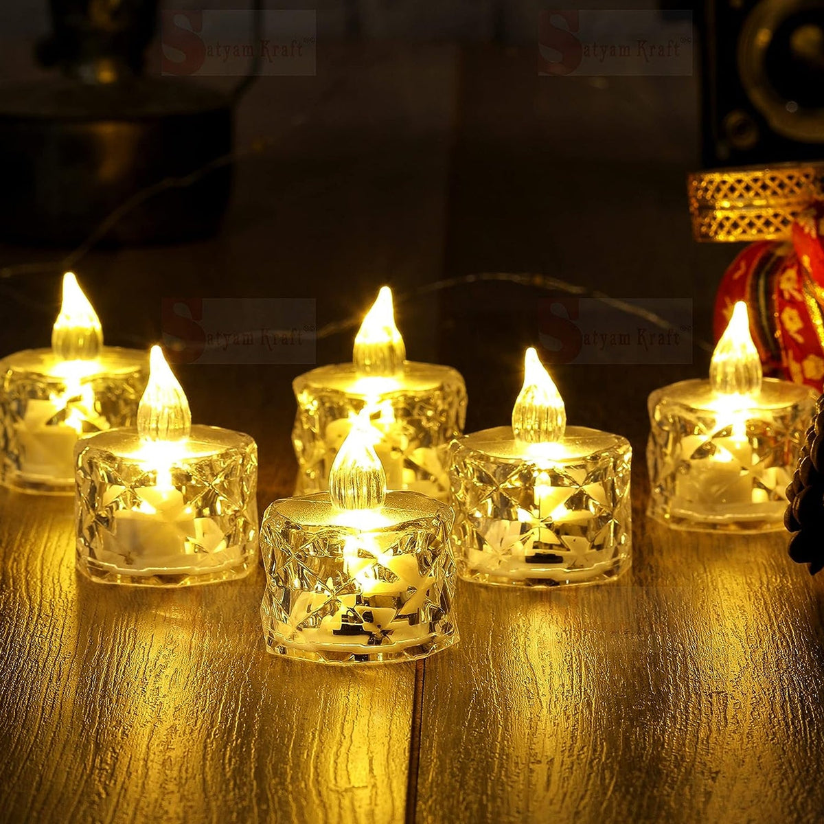 Six clear acrylic flameless LED tealight candles with warm yellow light on a reflective wooden surface.