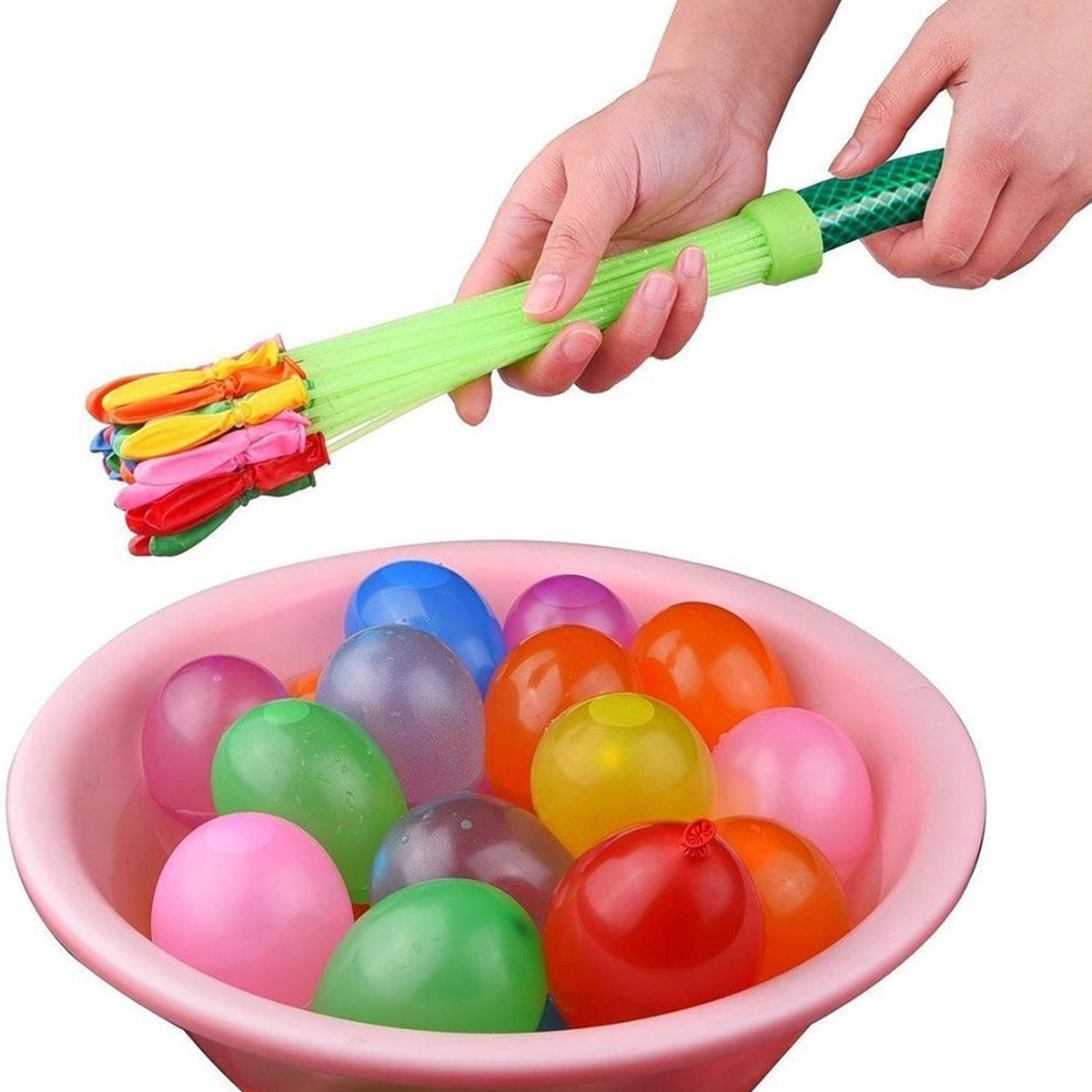 Hands holding a green water balloon nozzle over a pink bowl filled with colorful water balloons.