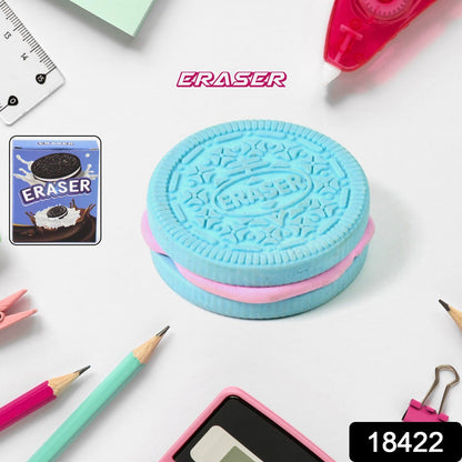 A blue and pink cookie-shaped eraser sits among various stationery items, including pencils and a ruler.