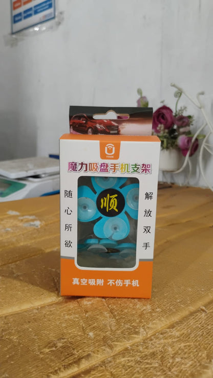 Flexible flower-shaped suction cup phone holder also functioning as a desktop stand for mobile devices.