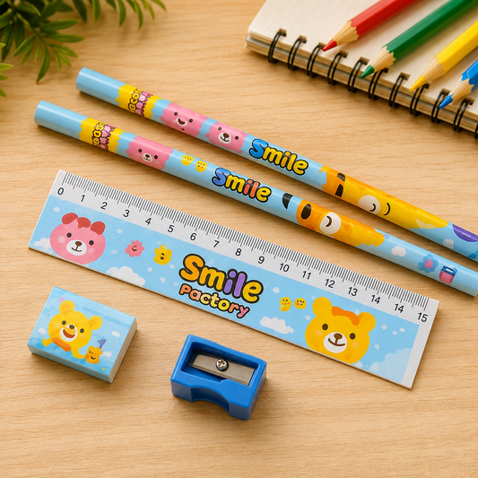 A 5-piece cartoon bear stationery set with pencils, ruler, eraser, and sharpener on a wooden desk with colored pencils.