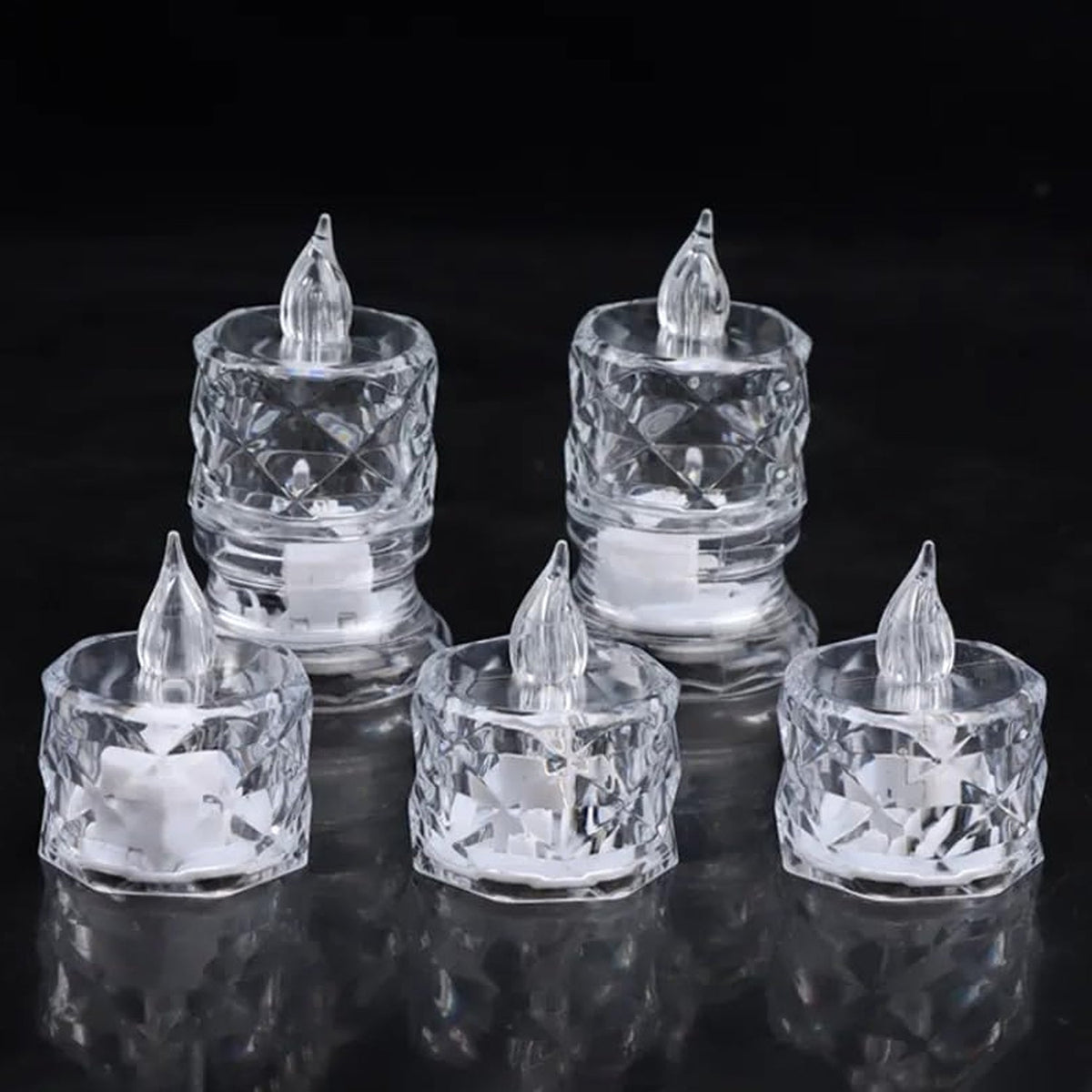 Five clear acrylic flameless LED tealight candles with clear plastic flames on a black reflective surface.
