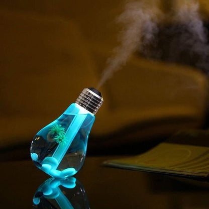 A blue bulb-shaped humidifier with palm trees inside emits mist, reflecting on a dark surface.