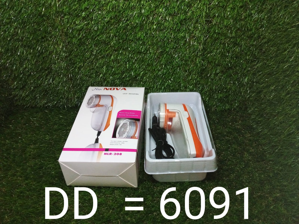 Orange and white lint remover in its packaging and out of the box on a green grassy surface.