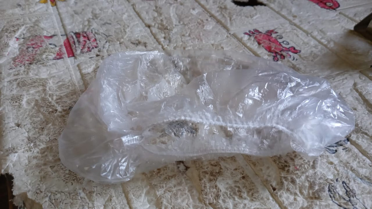 Disposable clear plastic shower caps displayed in a stack.