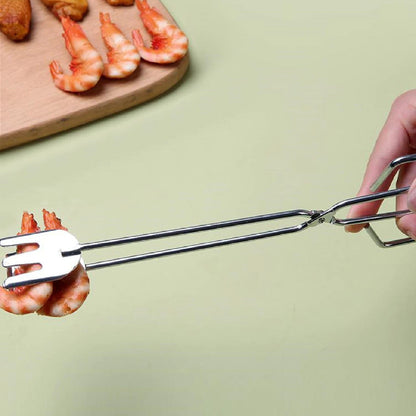 A hand using the stainless steel tongs to pick up cooked shrimp from a wooden cutting board.