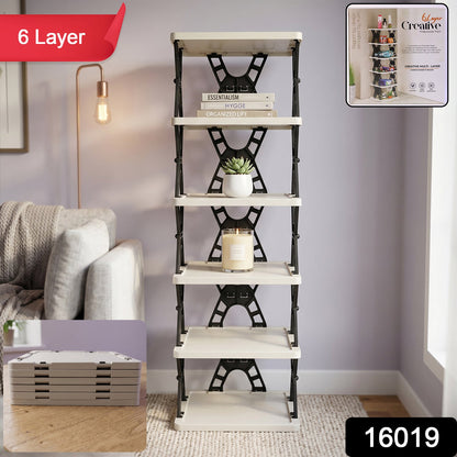 A 6-layer foldable shoe rack in a living room setting, with books, a plant, and a candle on its shelves.