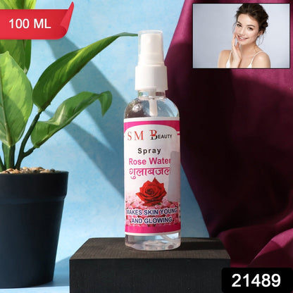 A clear bottle of SM Beauty rose water spray on a black block with a small inset image of a smiling woman.