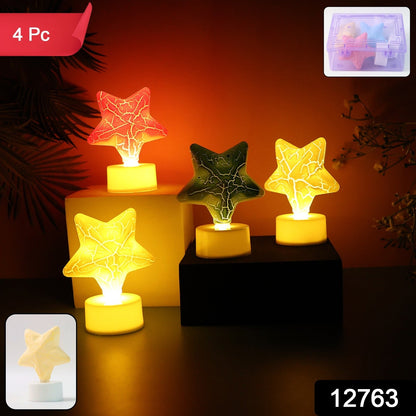Four glowing star-shaped LED tealight candles in red, green, and two yellow, with a small clear box inset.